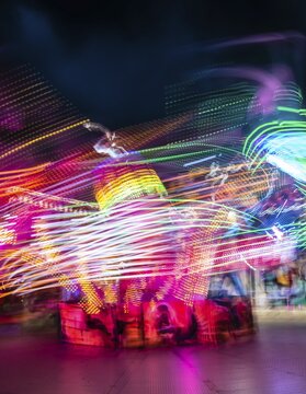Scattered light trails from a fairground ride at night, Munich Spring Festival, Theresienwiese, Munich, Bavaria, Germany