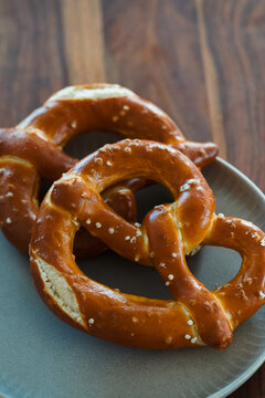 Freshly Baked Salted Soft Pretzels - bavarian lye brown pastry - on Wooden Board