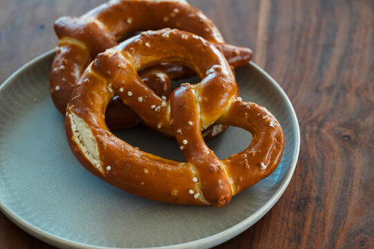Freshly Baked Salted Soft Pretzels - bavarian lye brown pastry - on Wooden Board