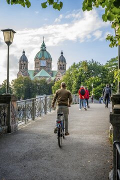 Church of St. Luke, passers-by on the cable footbridge over the Isar, Munich, Bavaria, Germany