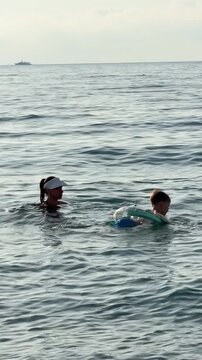Nice, France: a mother and child are swimming in the Mediterranean Sea.