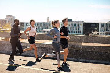 Fototapeta premium Running, group or people outdoor for fitness, runner club or race preparation with music. Cardio, team and marathon training with earphones in street for exercise, endurance and workout in city