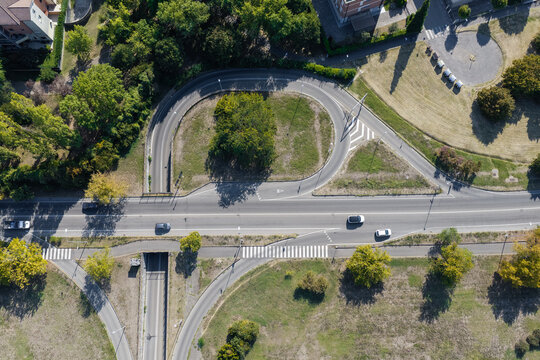 Aerial view of a road junction with a curved ramp and a pedestrian crossing in Modena, Emilia-Romagna, Italy.
