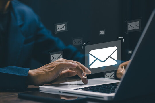 Business professional using laptop with virtual email icons, representing digital communication, online messaging, business correspondence, customer support, marketing and remote work.