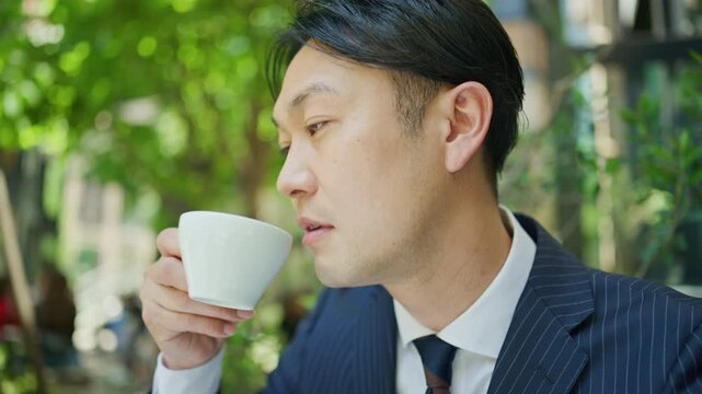 Close up of a businessman drinking coffee at an outdoor cafe