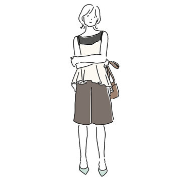 Stylish young woman wearing layered sleeveless top and peplum bustier with Bermuda shorts and heeled pumps