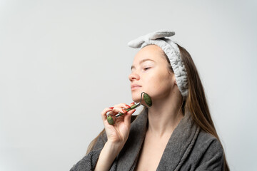 Woman using jade roller for face massage skincare ritual © lorenzophotoprojects