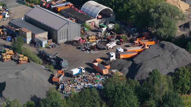 Aerial view of scrapyard with heavy machinery and industrial waste