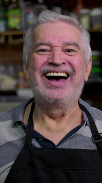 Senior barista chuckling heartily at checkout counter expressing radiant cheerfulness warm hospitality approachable service and vibrant neighborhood enterprise vitality