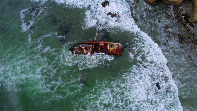 Top down aerial view of waves breaking around the rusted VICMAR shipwreck off the Baja California coast, Mexico