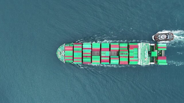 Aerial top view of cargo ship with contrail in the ocean sea ship carrying container and running from container international port smart freight shipping by ship service