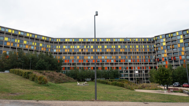 View of Park Hill Flats with its iconic colorful facade and brutalist architecture set against a grassy foreground in Sheffield, England, United Kingdom.