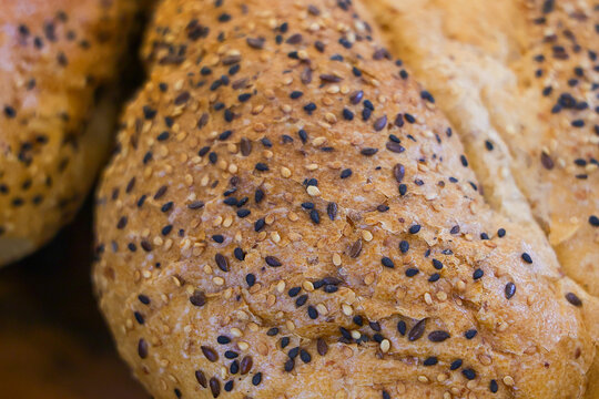 Multigrain bread loaf with sesame and flax seed crust, rustic bakery texture, warm golden surface, and appetizing detail