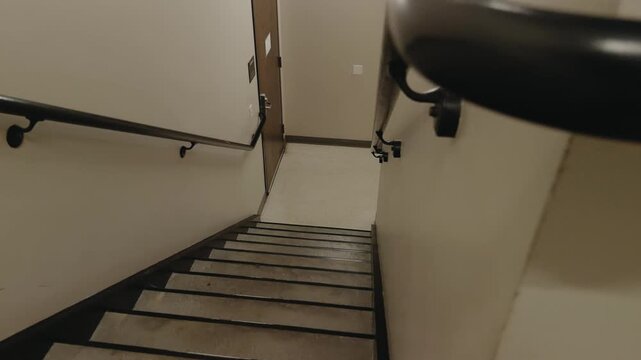 Left-to-right glide moves past black handrails and stairs in an empty stairwell.