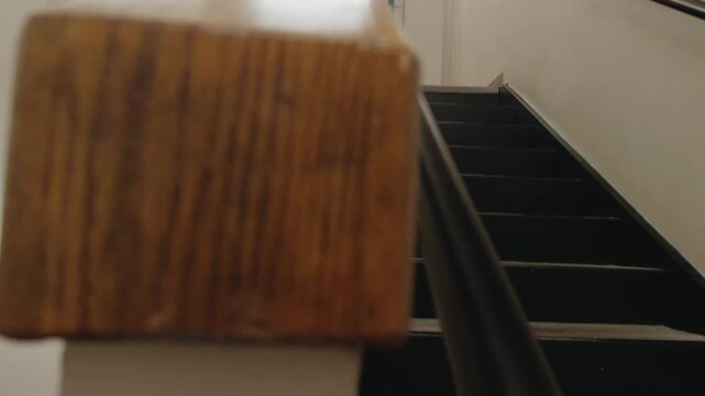 Diagonal pan moves from the upper stair rail down to the empty lower landing.