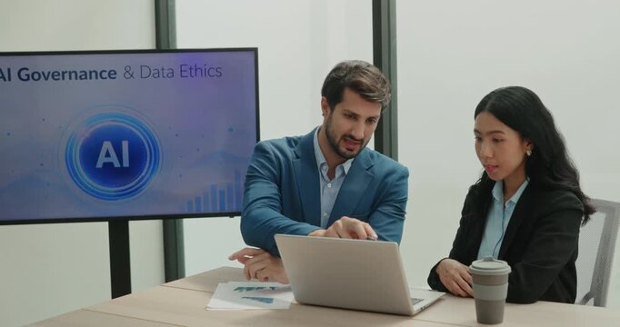 Portrait of Brasilian businessman discusses AI governance topic with Asian lady colleague near laptop. Manager gestures with hand and explains policy details
