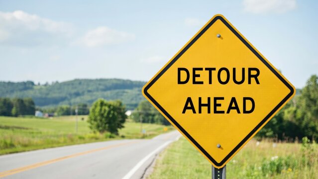 Yellow detour ahead diamond-shaped road sign on a rural highway