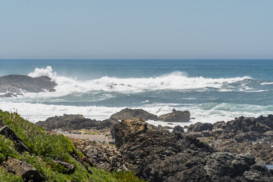 View of the rugged rocky coastline with crashing waves and deep blue Atlantic Ocean in Sines, Setubal, Portugal.