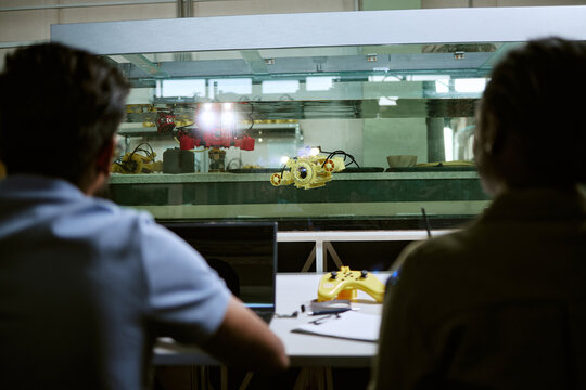 Multiethnic young students testing underwater robotic drone in water tank during engineering laboratory class. Useful for marine robotics, STEM education and technology innovation