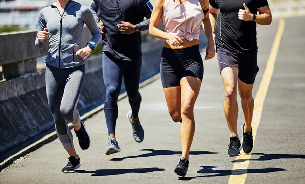 People, legs and running in city for fitness, challenge and muscle development for wellness. Runner group, feet and outdoor with pace for exercise, marathon preparation or friends in training program