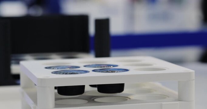 AI-powered robotic equipment uses vacuum suction cups to pick and sort used aluminum coffee capsules at an automated recycling facility. Innovative technology for processing foil coffee pod waste.