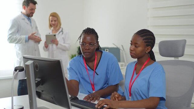 Two black female nurses collaborating in a doctor's office