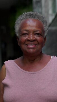 Gentle senior African American matriarch smiling softly at camera with warm affectionate gaze and peaceful wisdom