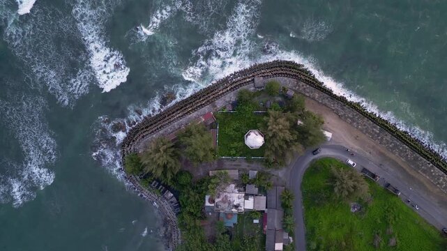 Meulaboh, Indonesia : Top down aerial drone footage of lighthouse in Meulaboh, coastal town in Aceh province of Sumatera in Indonesia with wave breaks into the coast