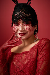 Naklejka premium Spooky Halloween beauty of smiling asian woman with bloody allure and lace headpiece