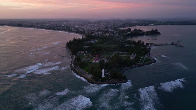 Meulaboh, Aceh : Aerial drone footage of Meulaboh, coastal town in Aceh province of Sumatera in Indonesia. Taken with forward motion showing light house and crowded town at sunset