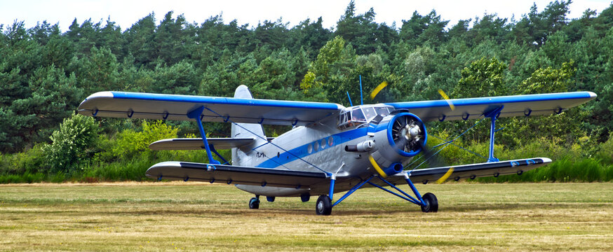 Biplane antonov an 2 aircraft taxiing on a grassy airfield, vintage propeller plane prepared for flight