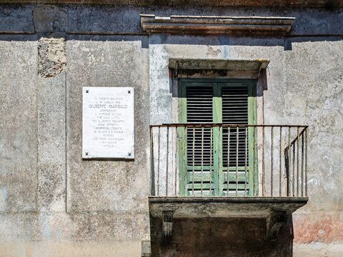 Historical travel photograph featuring the famous Garibaldi speech balcony and memorial plaque in Erice, ideal for Sicilian travel guides, Italian history, and cultural heritage media.