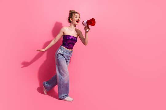 Young woman with a megaphone and stylish outfit on a vibrant pink background, embodying youth, fashion, charisma, and self-expression