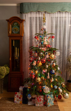 Cozy Christmas room interior with decorated tree and vintage grandfather clock.