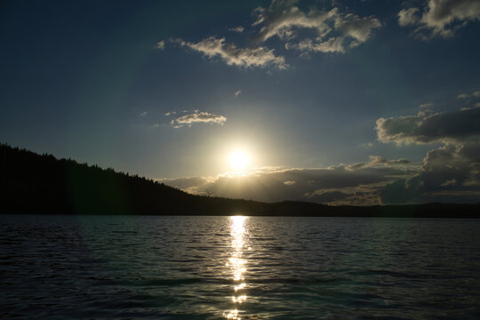 Radiant Sunset Over Calm Lake, in sweden, with Light Reflection.