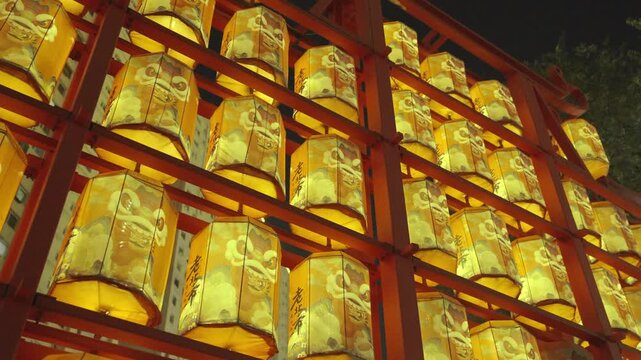 Glowing Yellow Lion Dance Lanterns on Red Metal Structure at Night