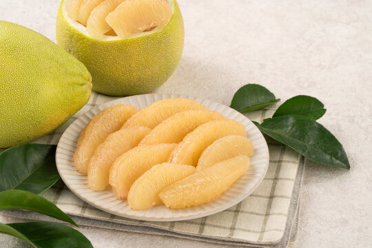 Fresh pomelo fruit with leaf on white table background.