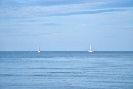 White Sailboat on Calm Baltic Sea Under Blue-Toned Sky