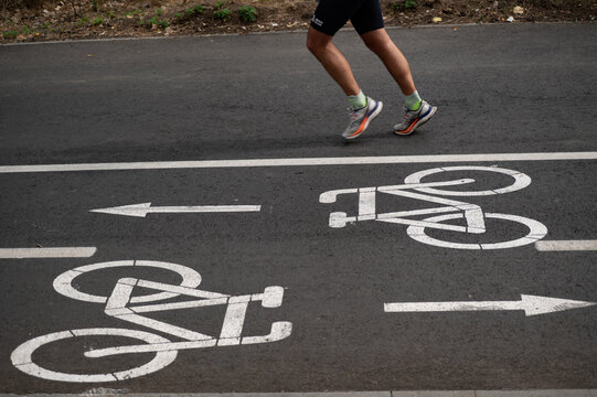 the feet of the runer run near the bicycle path