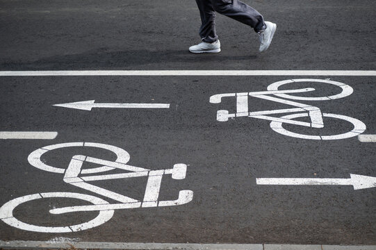 the feet of the runer run near the bicycle lane