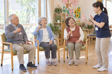 Fototapeta premium Japanese seniors enjoying handbell music at an adult day care center