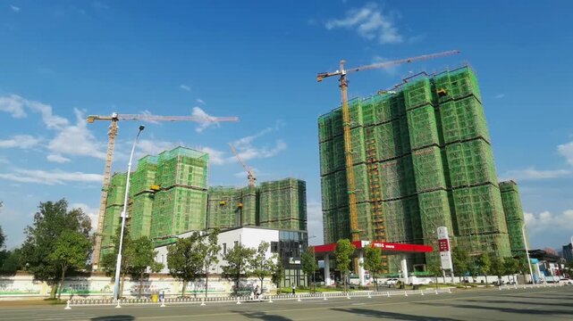 Residential High-Rise Buildings Under Construction with Green Safety Netting and Cranes