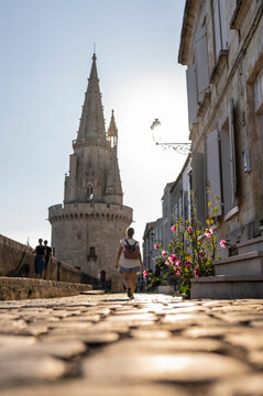 Calle empedrada con persona caminando de espaldas al atardecer