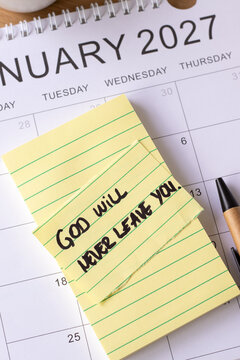 God will never leave you, handwritten encouragement quote on a note with January 2027 calendar. Christian peace and faith in Jesus Christ, biblical concept.