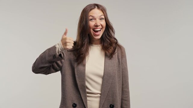 Happy college student female or businesswoman showing thumbs up with confident smile. Young woman approving great choice, success, recommendation and positive feedback.