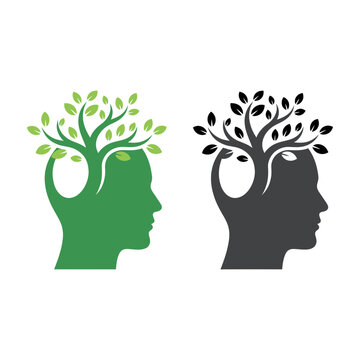 Green and black human head silhouettes with trees growing out