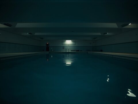 Generative AI depicting a dimly lit indoor swimming pool interior