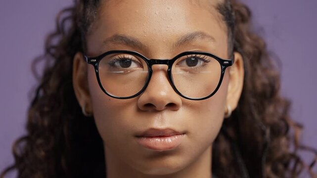 Serious school girl looking directly at camera with composed face expression. Confidence, leadership, resilience, self control and authentic personality.