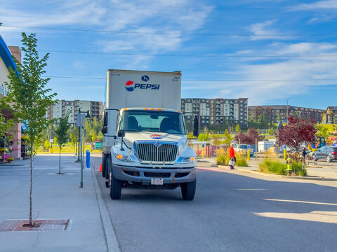 Calgary, AB, Canada - Sept 16, 2026: White Pepsi delivery truck parked outside a retail shopping plaza on a sunny day.
