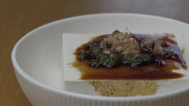 日本料理｜薬味がのった木綿豆腐の冷奴に醤油をかける